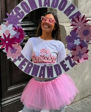 Recién recibida con tutú rosado sosteniendo un aro con flores lilas que dice Contadora Fernández